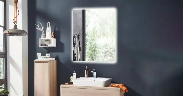 Specchio rettangolare retroilluminato sopra un mobile lavabo in legno