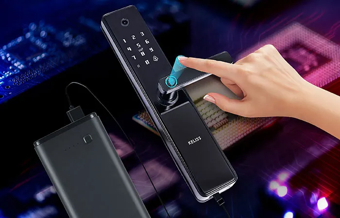 Batteria portatile collegata a una serratura smart mentre un dito tocca il lettore d'impronte