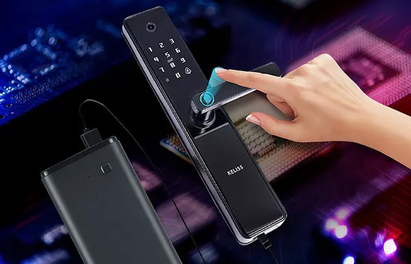 Batteria portatile collegata a una serratura smart mentre un dito tocca il lettore d'impronte